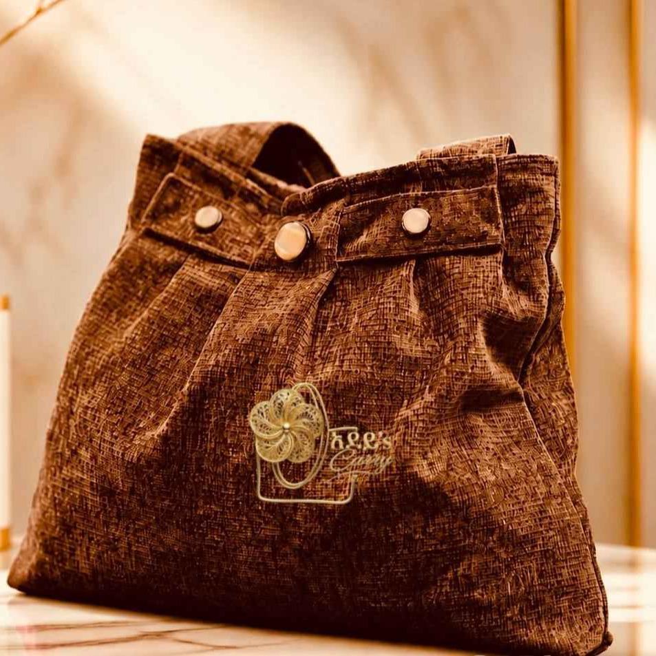 Adeys carry bag showcasing signature stitching, logo, and textured fabric with a spacious interior